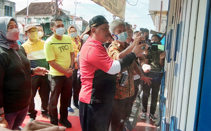 Plt Bupati Marhaen Jumadi secara simbolis melakukan pengecatan sebuah rumah, menandai dilaksanakannya gerakan pelangi di Jalan A Yani. foto: BAMBANG DJ/BANGSAONLINE