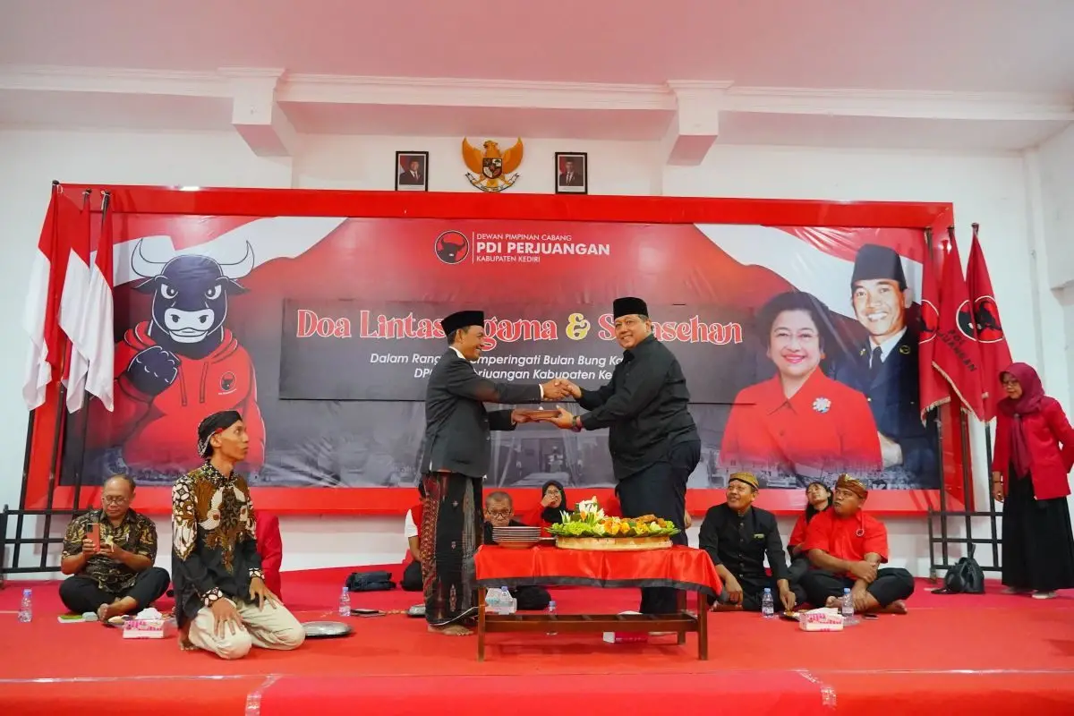 Sekretaris PDI Perjuangan Kabupaten Kediri Dodi Purwanto (kanan) saat menyerahkan potongan tumpeng kepada tokoh agama. (Ist). 