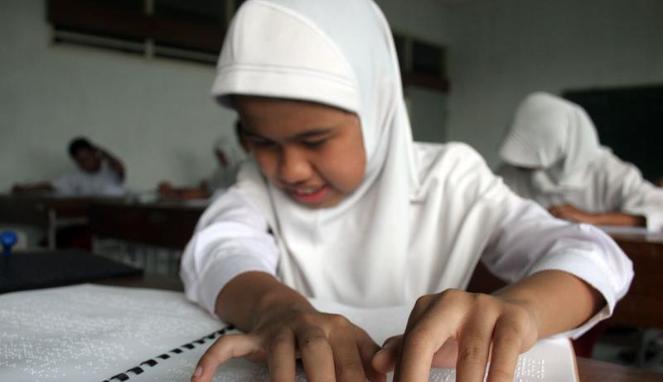 Seorang siswi SD disalah satu SLB di Yogyakarta sedang mengerjakan Ujian Nasional. foto: viva.co.id