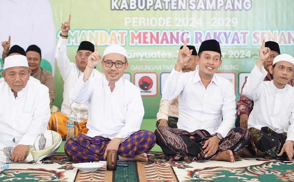 Pasangan calon KH. Muhammad Bin Muafi Zaini dan Abdullah Hidayat berpose satu jari saat menghadiri pengukuhan Tim Mandat.