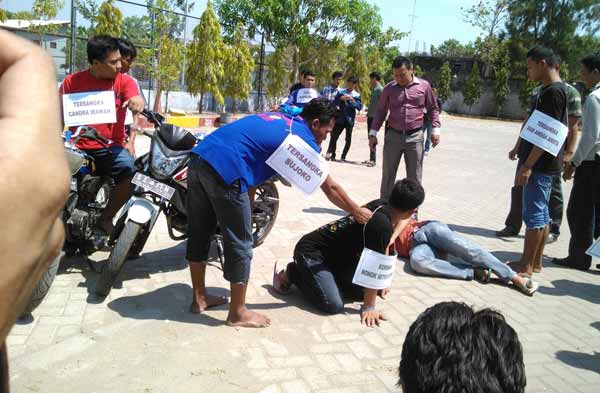 Salah satu adegan pengeroyokan saat diperagakan tiga tersangka. foto: eki nurhadi/BANGSAONLINE
