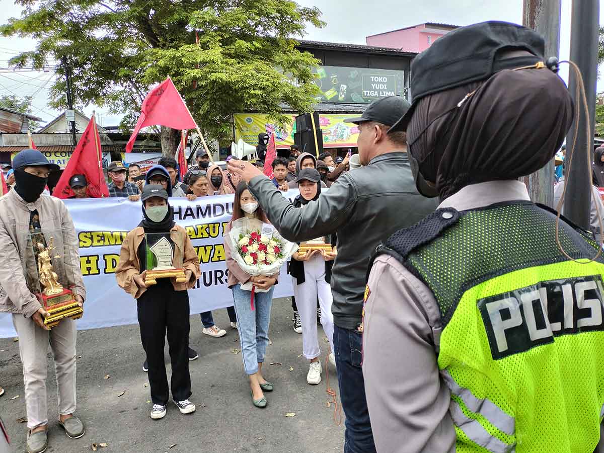 Massa aksi yang tergabung dalam Forum Masyarakat Blitar Raya (FMBR), saat memberikan rangkaian bunga untuk Kapolres Blitar Kota,  AKBP Argowiyono, Senin (6/2/2023).