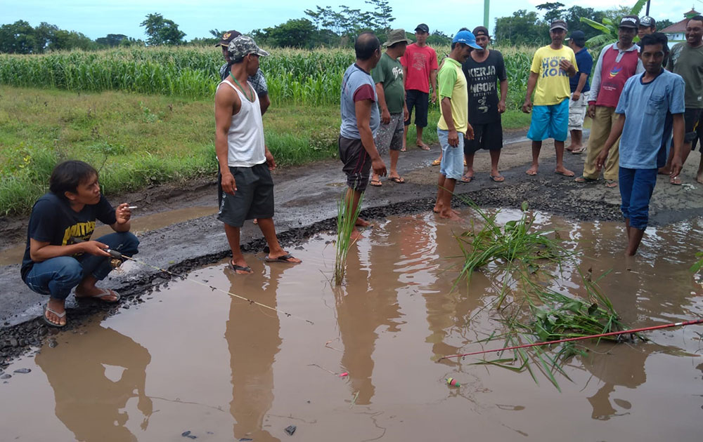 Sejumlah warga dari Desa Ngepoh, Kecamatan Dringu, Kabupaten Probolinggo, menggelar aksi protes di tengah jalan yang rusak.