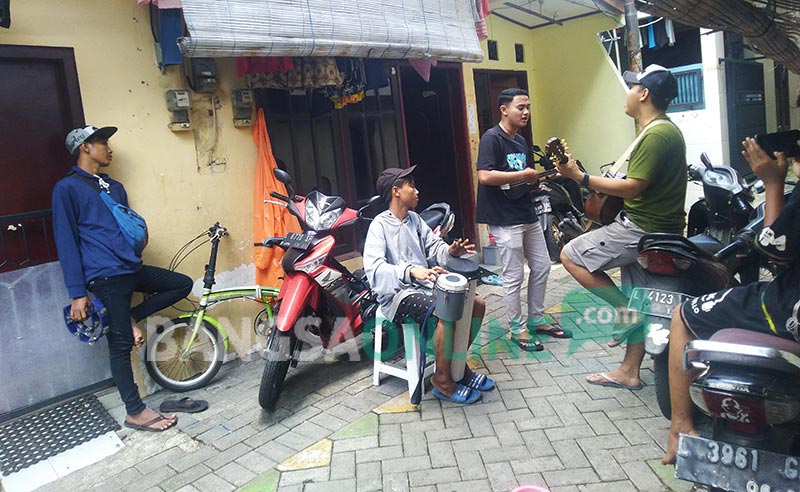 Sulton Nawawi, berkaos oblong hitam saat ngamen bersama gropnya dari kampung ke kampung. foto: NANANG FACHRUROZI/ BANGSAONLINE