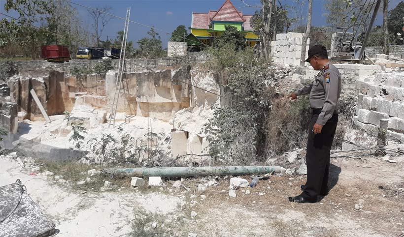 Petugas menunjukkan tebing batu kumbung yang longsor.