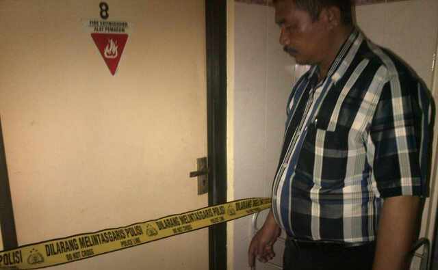 GARIS POLISI – Petugas Polsek Sedati memasang garis polisi depan kamar lokasi ditemukannya penghuni kos meninggal, di Desa Sedati Gede, Kecamatan Sedati, Sidoarjo, Rabu (21/1/2015). Foto: nanang ichwan/BangsaOnline
