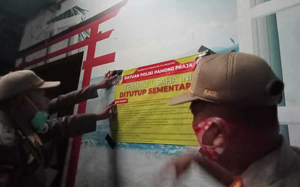 Petugas gabungan di Tulungagung saat menyegel salah satu kafe yang melanggar aturan saat Ramadhan.
