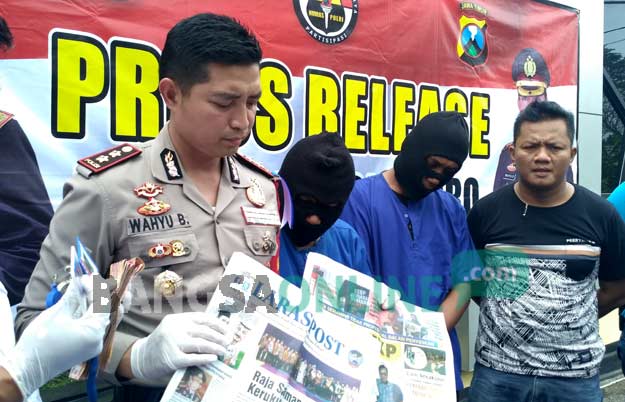 Kapolres Bojonegoro menunjukkan dua wartawan abal-abal dan barang bukti berupa uang serta koran mingguan yang diterbitkan pelaku. foto: EKY NURHADI/ BANGSAONLINE