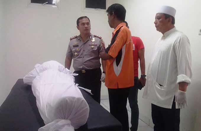 Petugas memeriksa jenazah penjahat yang ditembak mati di tempat, karena meresahkan masyarakat. 