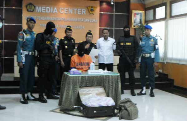 PENYELUNDUP: Petugas Kantor Pengawasan Pelayanan Bea dan Cukai (KPPBC) Tipe Madya Pabean Juanda menunjukkan tersangka penyelundup dan BB narkoba, Senin (16/11). foto : catur andy erlambang/BANGSAONLINE