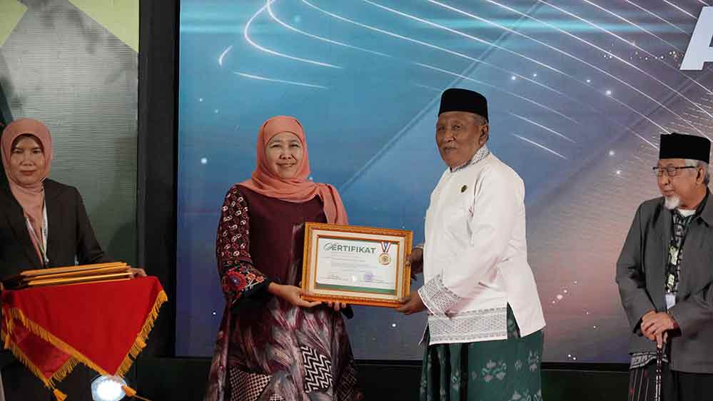 Ketua Umum MUI Kabupaten Gresik KH. Ainur Rofiq Thoyyib (kanan) menerima penghargaan dari Gubernur Jatim sekaligus Ketua Dewan Pertimbangan MUI Jatim, Khofifah Indar Parawansa. (Ist)