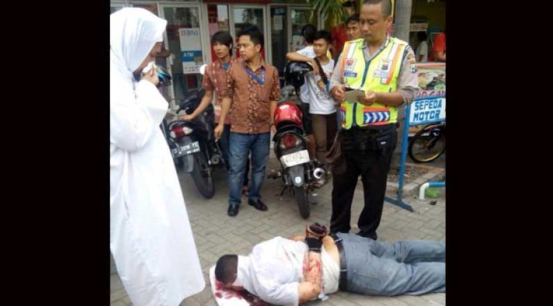 BERSIMBAH DARAH: Korban tersungkur usai dihajar massa. foto: beritajatim