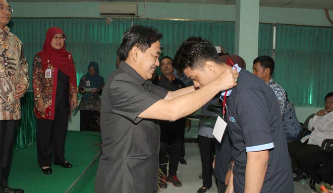 SIMBOLIS: Wabup Sidoarjo H Nur Ahmad Syaifuddin mengalungkan tanda peserta kepada buruh pabrik plastik yang mengikuti diklat, Senin (18/7). foto istimewa