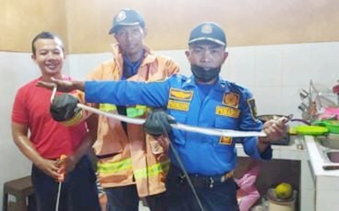 Tim Damkar Kabupaten Sumenep usai berhasil mengevakuasi ular jali atau Ptyas korros di rumah warga.