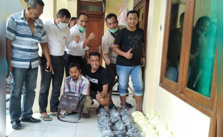 Tersangka AS (jongkok pegang tas) saat diamankan beserta barang bukti puluhan kilogram bahan peledak.