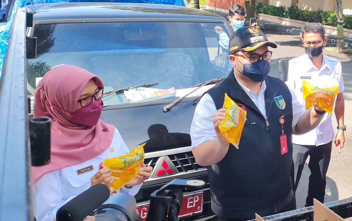 Bupati Kediri Hanindhito Himawan Pramana didampingi Kepala Dinas Perdagangan Tutik Purwaningsih saat mengecek minyak goreng yang akan didistribusikan kepada para pedagang di sejumlah pasar tradisional. foto: MUJI HARJITA/ BANGSAONLINE