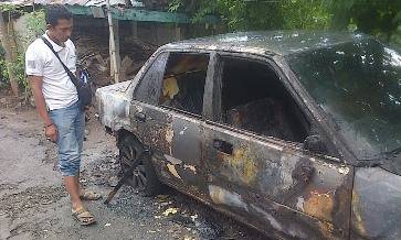Mobil sedan milik perangkat desa Gunung Putri yang dibakar orang tak dikenal. (Hadi Prayitno/BANGSAONLINE)