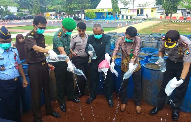 Jajaran Forpimda saat menuangkan miras ke dalam tanah galian. foto: SUWANDI/ BANGSAONLINE