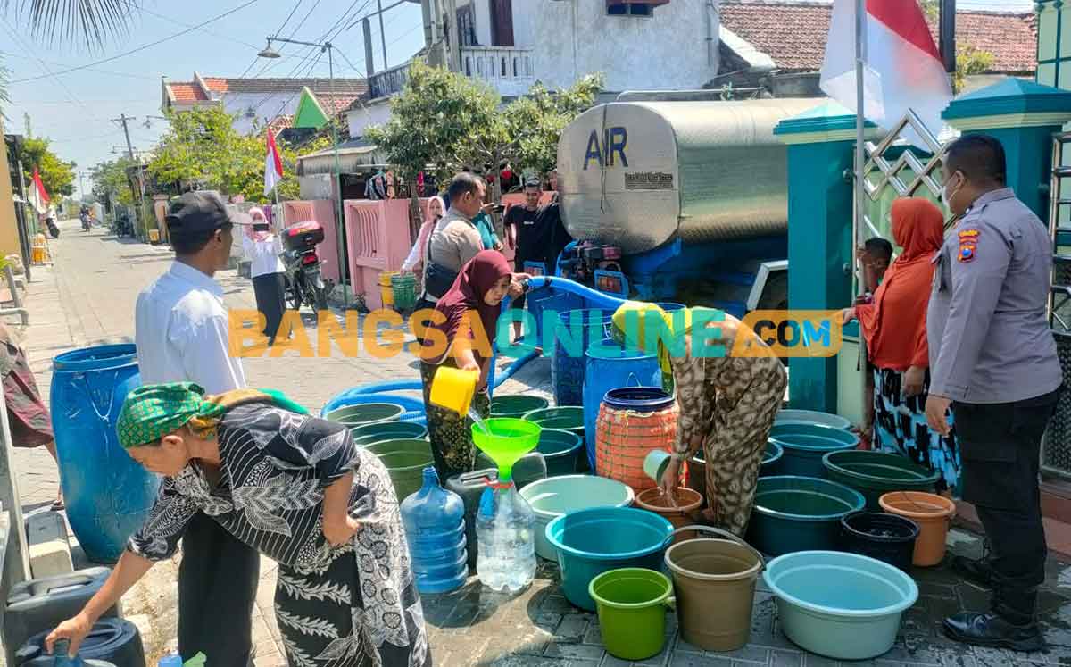 Petugas Polres Gresik saat mengirim air bersih di sekitar Kecamatan Duduksampeyan. Foto: SYUHUD/BANGSAONLINE

