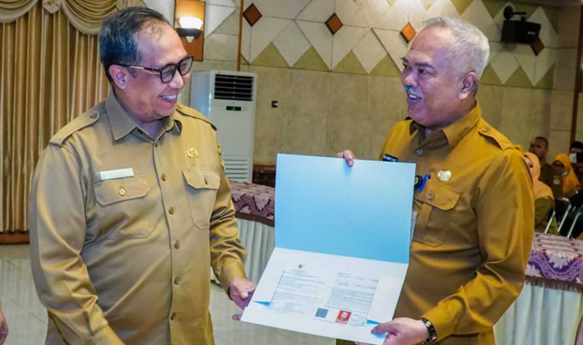 Sekdakab Gresik (kiri) dan Kepala Disperta, Eko Anindito Putro, saat penyerahan SK pensiun. Foto: Ist