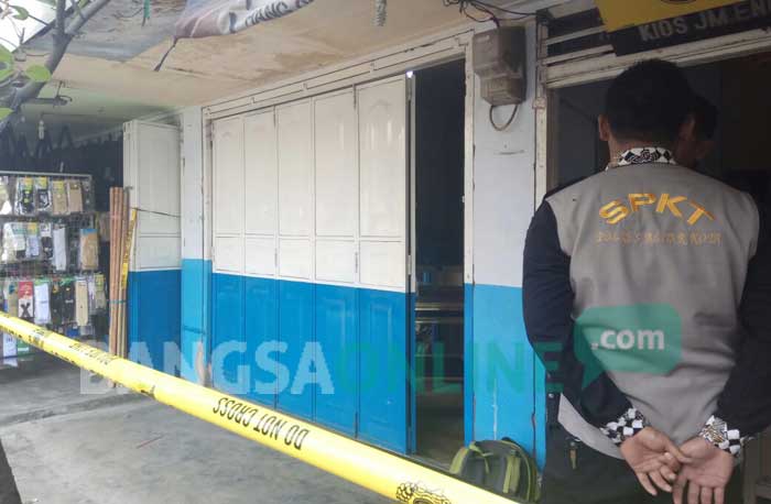 Garis polisi nampak dipasang di toko emas milik Askuri setelah disatroni kawanan perampok. foto: AKINA/ BANGSAONLINE