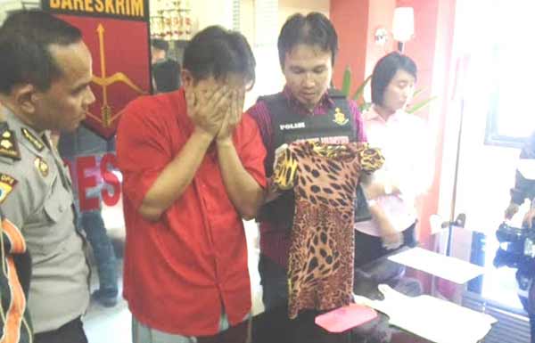 Wakasat Reskrim di samping tersangka menunjukan baju korban. (rusmiyanto/BANGSAONLINE)