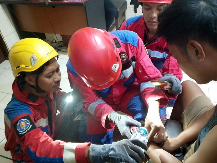 Proses pembukaan borgol tahanan yang macet di Polsek Semampir, Surabaya. Foto: Ist.