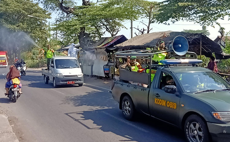 Kapten Inf. Edi Suryanto langsung mengambil pimpinan dalam giat pembagian masker dan penyemprotan disinfektan di sejumlah jalan di Pasuruan.