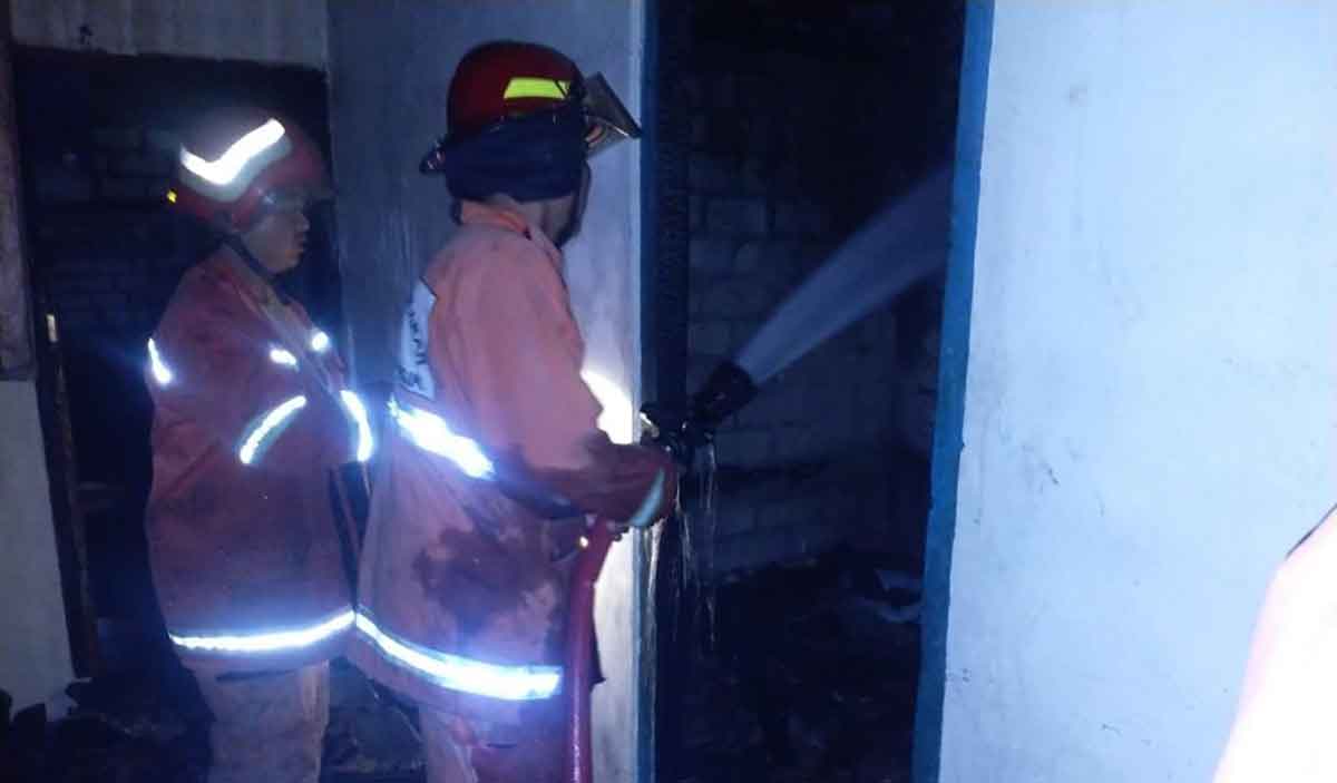 Petugas Damkar Gresik ketika memadamkan rumah korban yang terbakar. Foto: Ist
