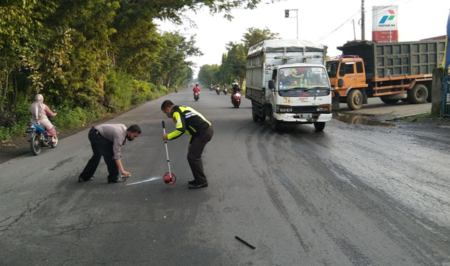 Petugas kepolisian saat melakukan olah TKP di Jalan Raya Prambon, Sidoarjo.