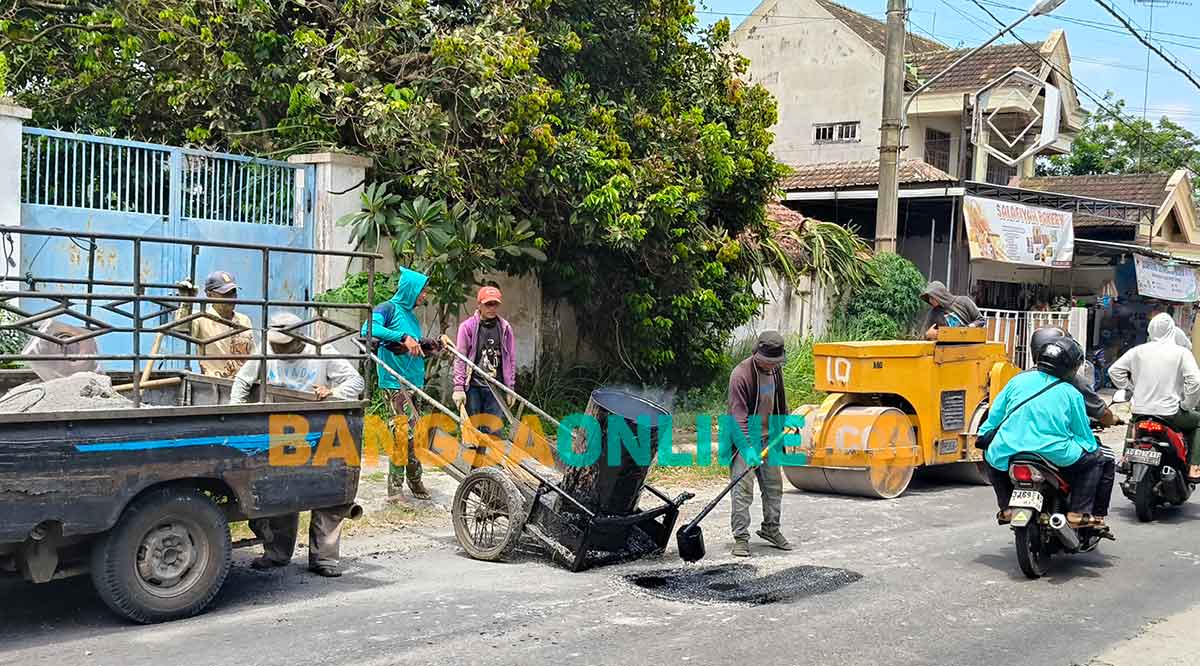 Para pekerja saat mengerjakan penambalan jalan berlubang di wilayah Kecamatan Ngasem. Foto: MUJI HARJITA/BANGSAONLINE