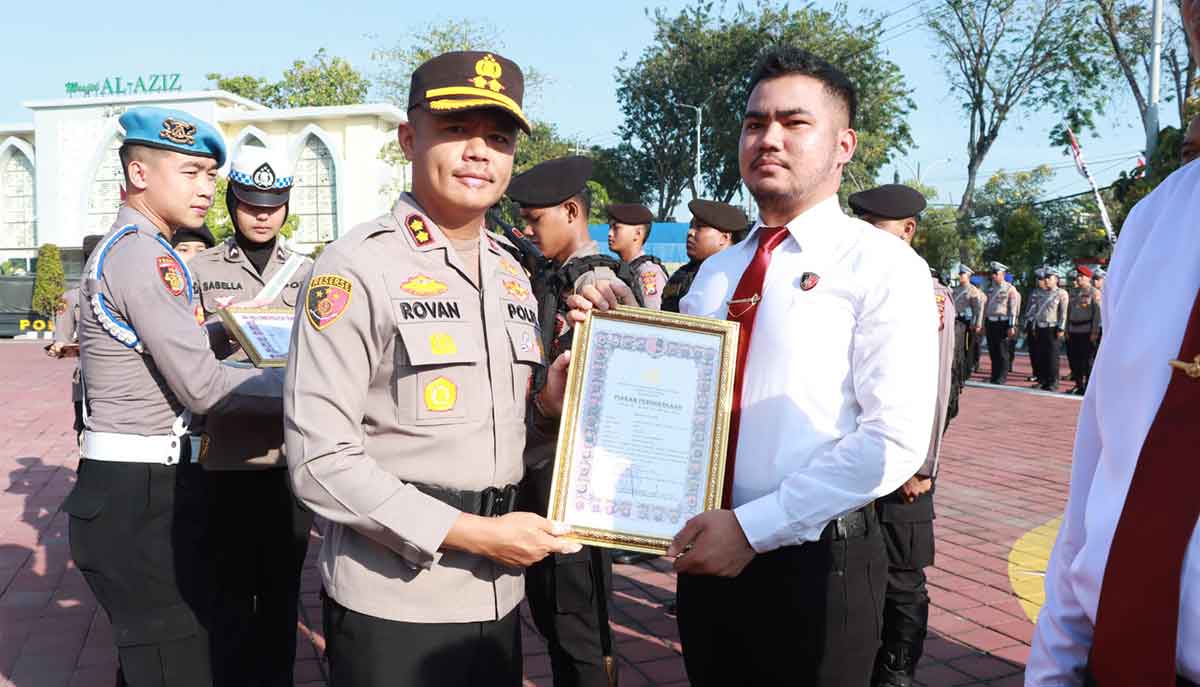Kapolres Gresik AKBP Rovan Richard Mahenu (kiri) saat memberikan penghargaan kepada personel berprestasi. Foto: Ist