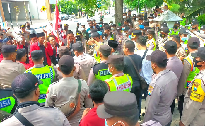 Massa dari GMNI Jombang saat dihadang petugas di depan kantor dewan setempat.