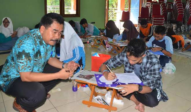 BERI SEMANGAT: Kepala Diskopindag Lamongan, Gunadi saat meninjau lomba membatik. foto: nurqomar/ BANGSAONLINE