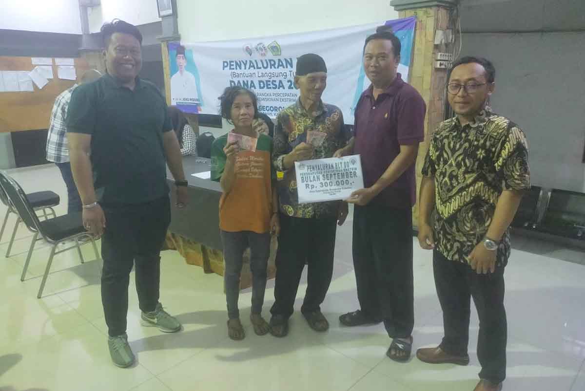 Kades Segoromadu, Eko Wahyudi, ketika menyerahkan BLT kepada warga tidak mampu. Foto: Ist