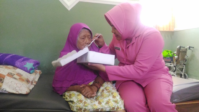 Susi Asfuri, istri Kapolres Malang Kota AKBP. Asfuri, saat menyuapi seorang Lansia di Pondok Lansia Blimbing Malang, penuh dengan ketelatenan dan kesabaran, Kamis (27/9). Foto: IWAN I/BANGSAONLINE