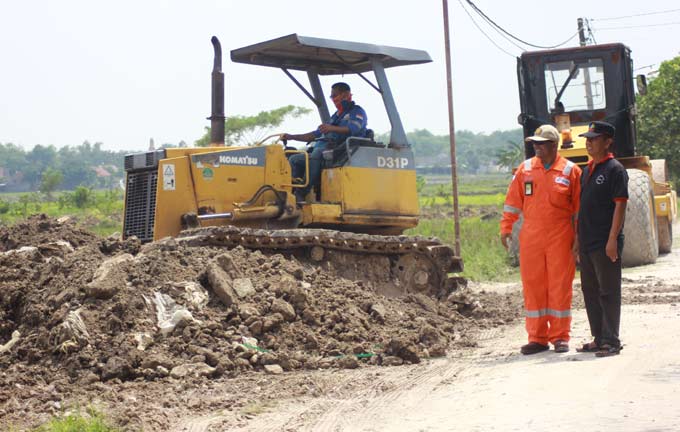 Field Administration and Superintendent JOB P-PEJ, Akbar Pradima (orange) dan Kepala Desa Campurejo, Edi Sampurno (hitam) saat memantau perataan tanah untuk pembuatan taman rekreasi dan edukasi. foto: EKY NURHADI/ BANGSAONLINE
