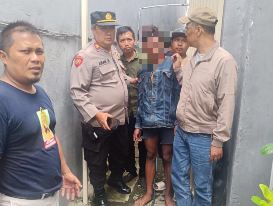 Petugas Polsek Tambaksari mengamankan terduga pelaku usai menjadi sasaran amukan warga