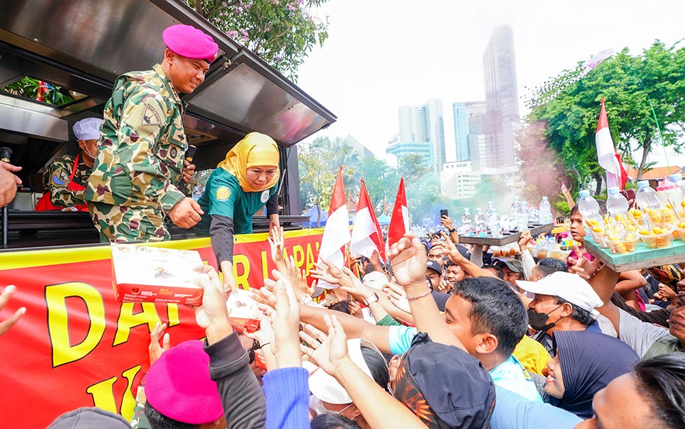 Gubernur Jawa Timur, Khofifah Indar Parawansa, menyapa masyarakat yang menghadiri perayaan Indonesian Marines Day dalam rangka Hari Ulang Tahun ke-80 Korps Marinir TNI Angkatan Laut yang digelar di sepanjang Jalan Pemuda depan Grahadi dan Taman Apsari Surabaya, Minggu (9/11/2025).