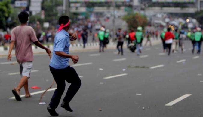 Pengemudi taksi dan pengemudi ojek online terlibat aksi saling lempar batu di Jalan Sudirman, Jakarta, Selasa (22/3). foto: kompas.com