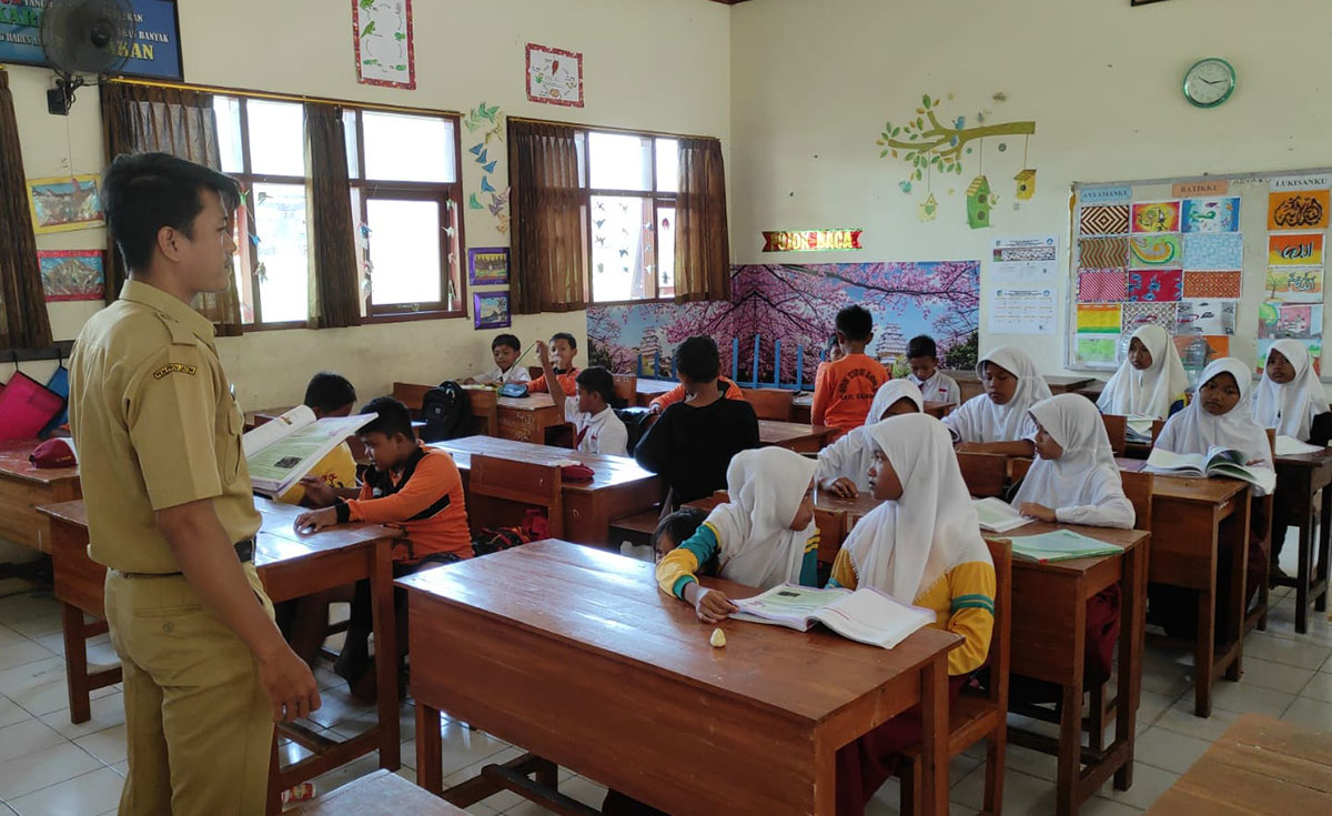 Marga Cistha saat mengajar di depan murid-muridnya. Foto: Ist.