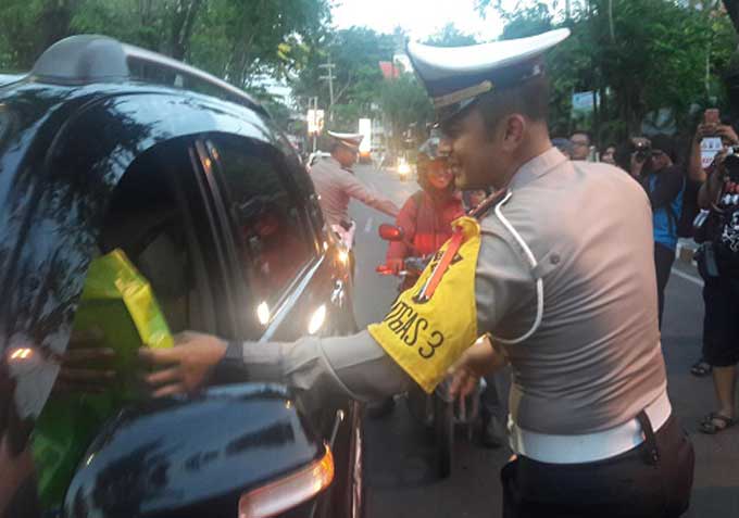 Kasatlantas Polres Gresik AKP Whika Ardilestanto membagikan takjil gratis kepada pengguna jalan di depan gedung WEP Gresik. foto: SYUHUD/ BANGSAONLINE