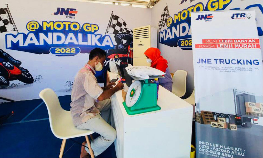 Pengunjung MotoGP Mandalika melakukan transaksi pengiriman di stan JNE. foto: ist.