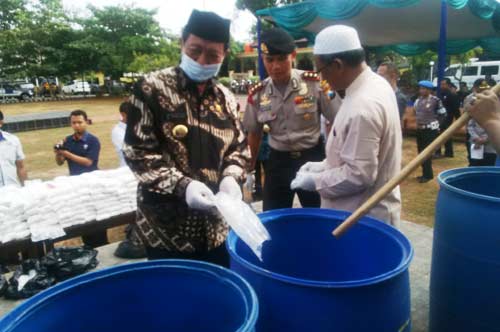 Kapolres Tuban, AKPB Guruh Arif darmawan ketika melakukan pemusnahan pil koplo dan sabu-sabu bersama Bupati Tuban, H. Fathul Huda. (foto: suwandi/BANGSAONLINE)
