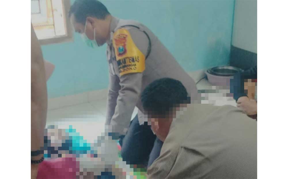 Petugas Polres Blitar saat memeriksa tubuh korban.