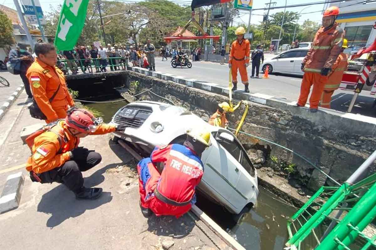 Anggota BPBD Kota Surabaya saat melakukan evakuasi mobil yang tercebur ke sungai di Jalan Arief Rahman Hakim, Sukolilo, Kamis (28/9/2023).