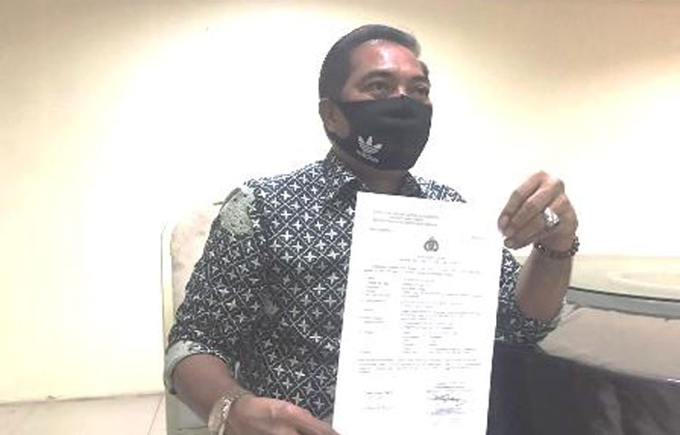 Kuasa hukum pelapor, Muara Harianja menunjukkan bukti laporan ke Polda Jatim.