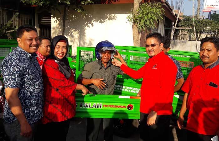 Nasyirul Falah Amru didampingi Siti Muafiyah saat menyerahkan motor sampah secara simbolis.
