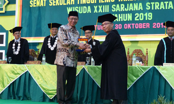 Bupati Tuban, H Fathul Huda saat memberikan piagam kepada salah satu wisudawan berprestasi.