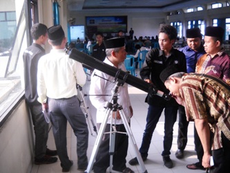 Peserta seminar mencoba mengoperasikan teropong untuk melihat posisi matahari, di kantor PCNU Sidoarjo, Minggu (22/6). foto musta’in/BANGSAONLINE